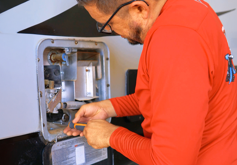 RV technician repairing an RV water heater