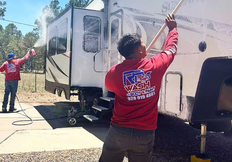 Roberts RV Solutions crew washing the side of a travel trailer